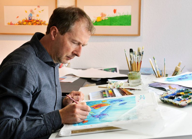 Švicarski pisatelj in ilustrator Marcus Pfister med ustvarjanjem Mavrične ribice